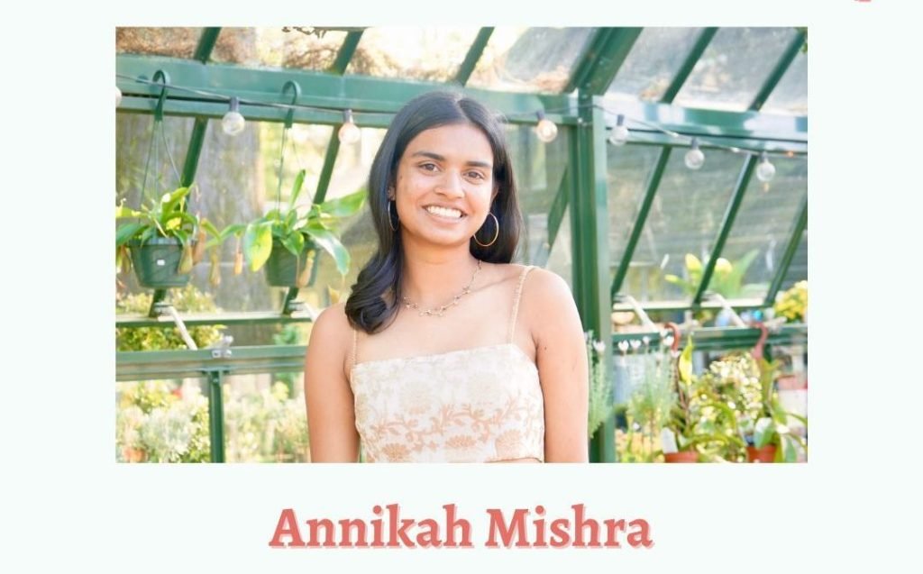 A smiling headshot of Annikah Mishra, an influential young woman, stands in front of a greenhouse. Below the image, her name is written in pink text.
