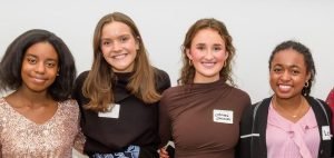 Photo of four young women smiling and standing together in a group, with a sign above them that reads "Meet the Springboarders." The image is related to a Teen Advisory Board.
